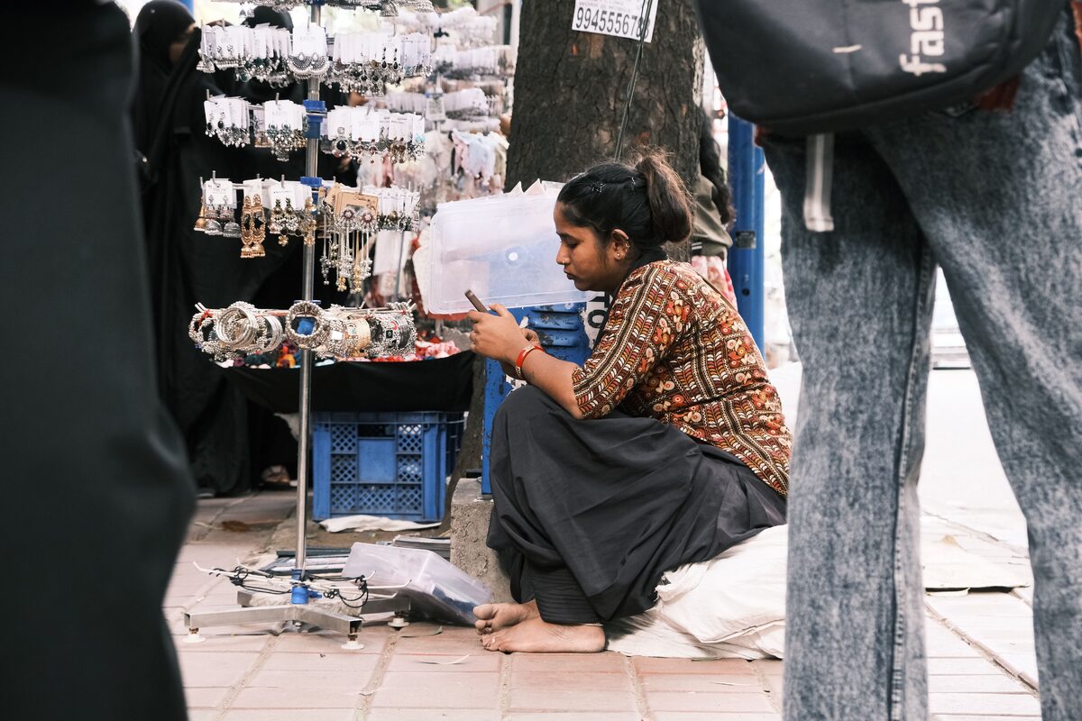A street vendor in Bengaluru, India, selling jewelry at a bustling market.
