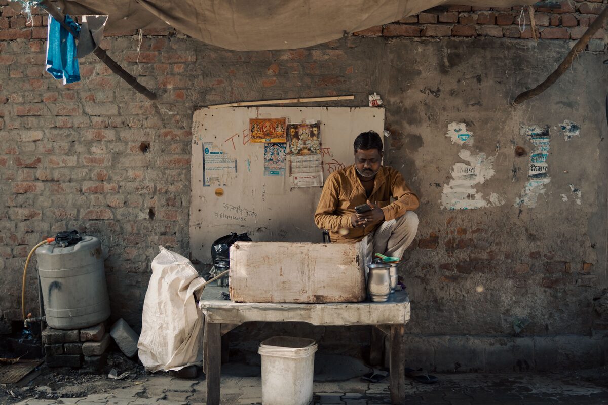 A street vendor in Ludhiana, Punjab, India using a mobile phone while working.