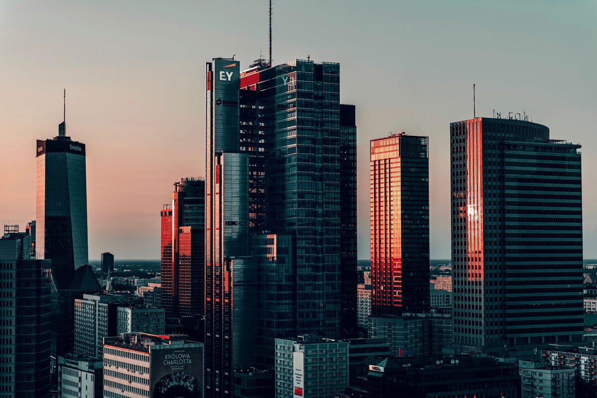 A stunning view of Warsaw's modern office buildings at sunset, showcasing city life and architecture.