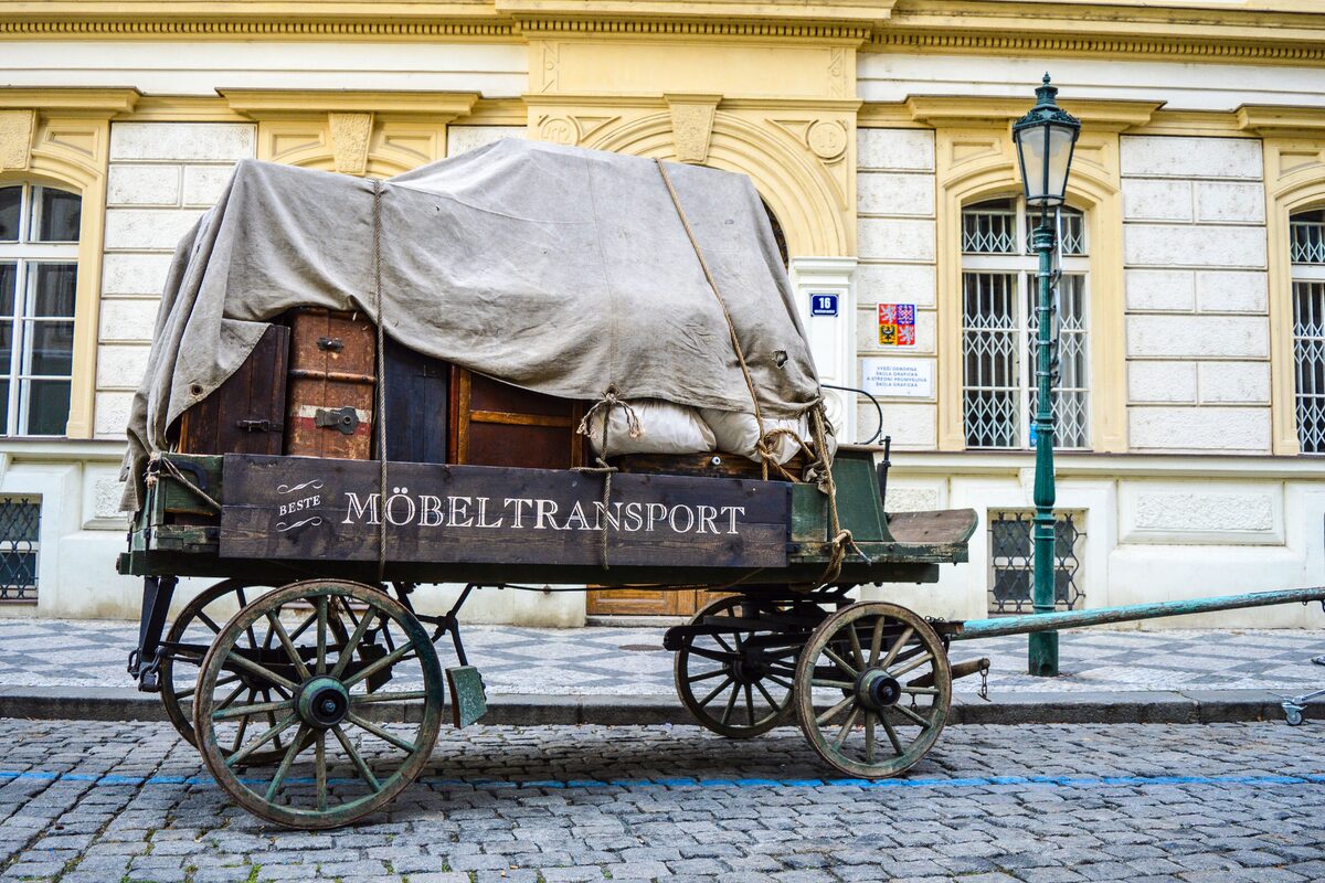 A historical covered wagon parked on a classic cobblestone street, showcasing European charm and vintage style.