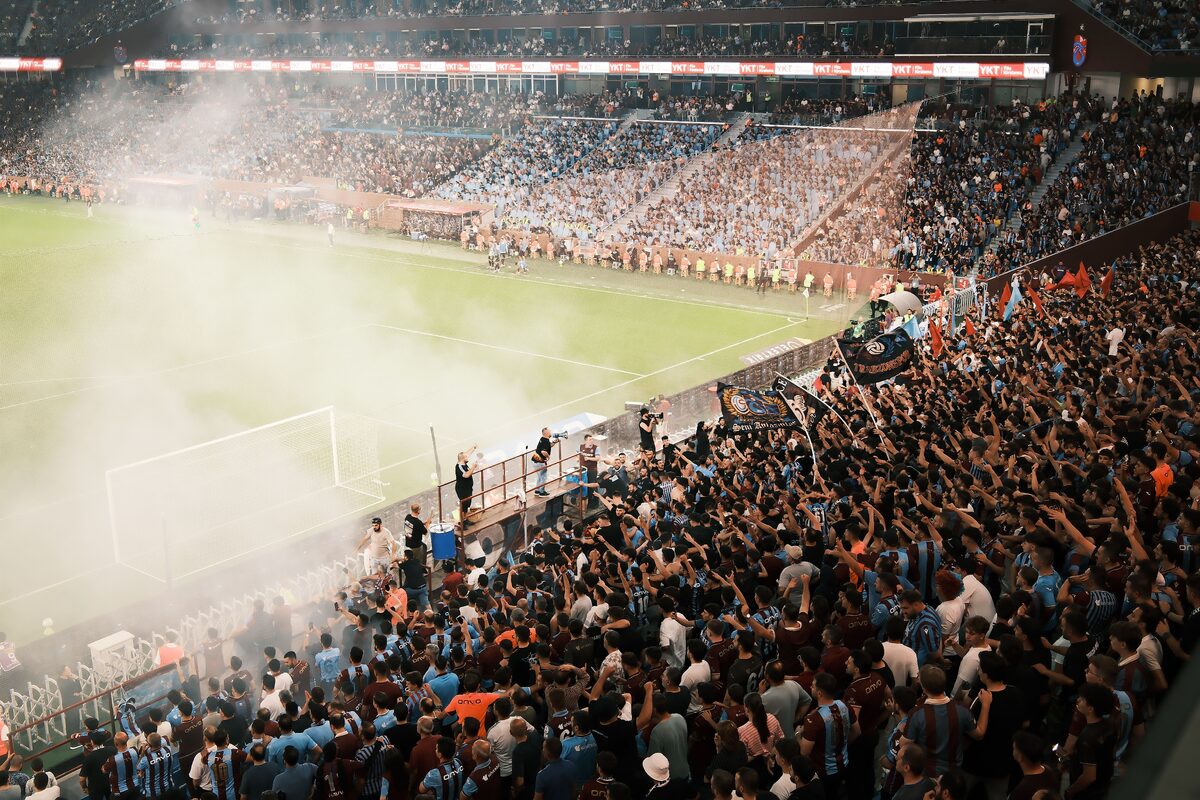 A vibrant scene of a packed soccer stadium with enthusiastic fans cheering during a match.