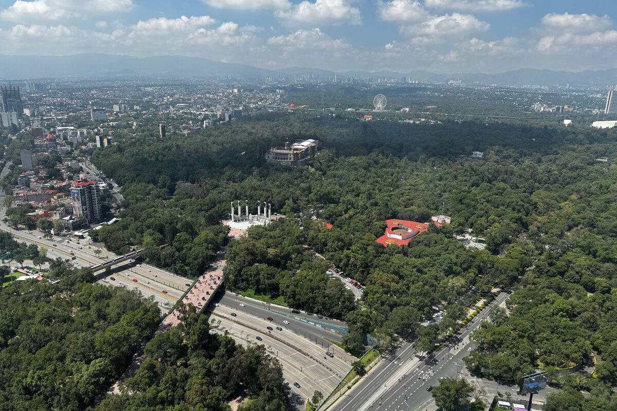A stunning aerial view of Chapultepec Park with cityscape and mountains in the background.