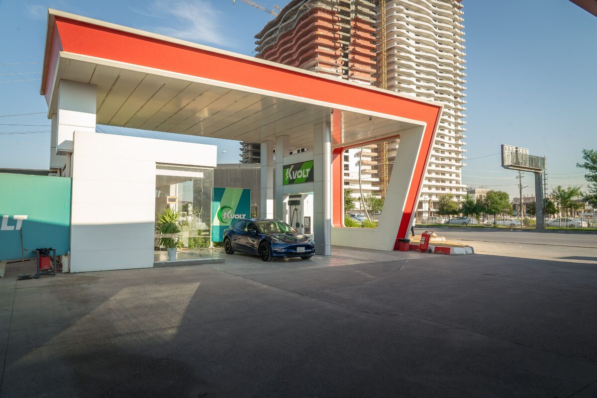Electric vehicle at a modern charging station in an urban setting, promoting sustainability.