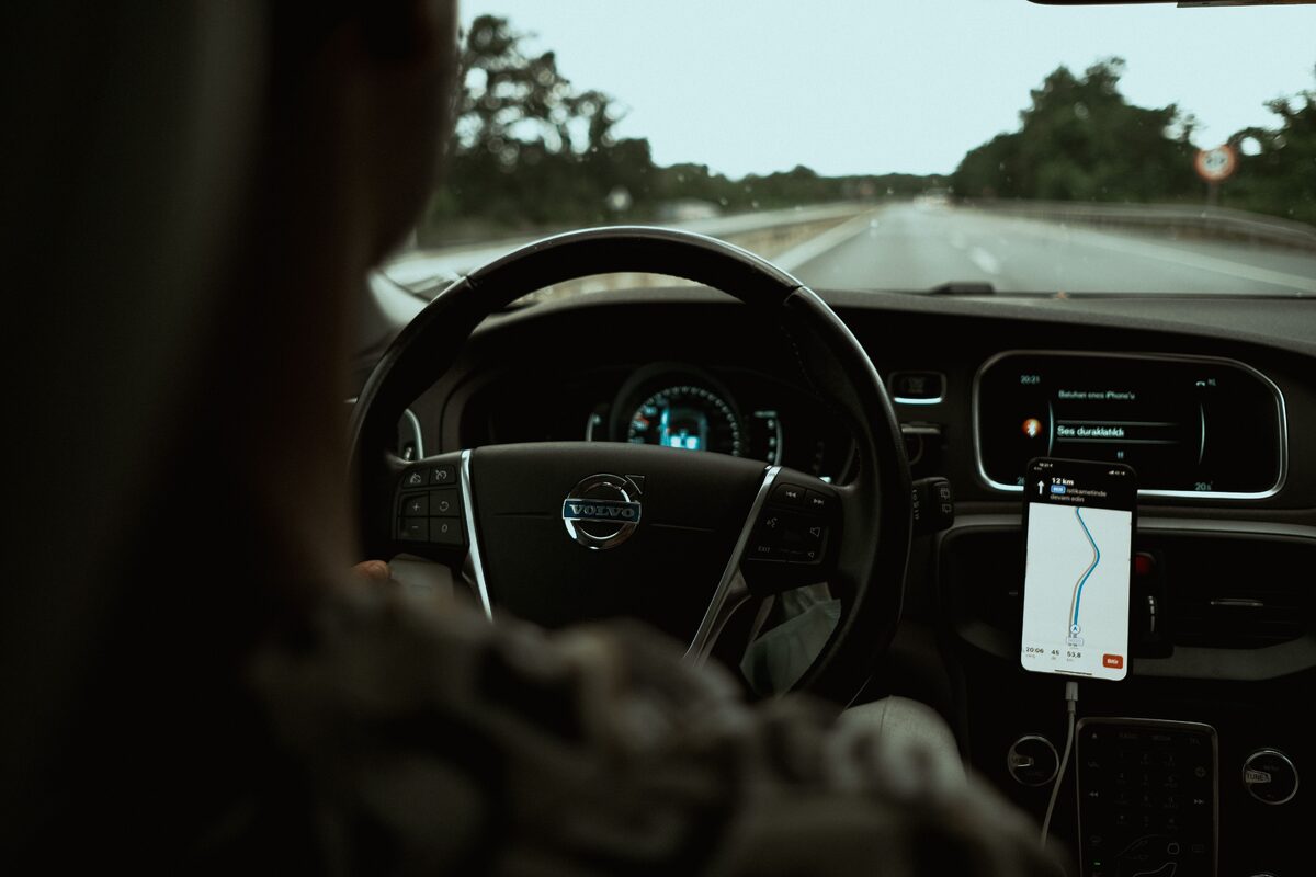 Interior view of a car on the highway using a GPS navigation app on a smartphone