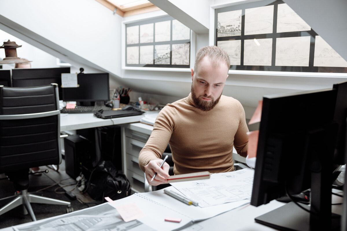 Architect focused on project designs in a bright, modern office space. Ideal for business or design themes.
