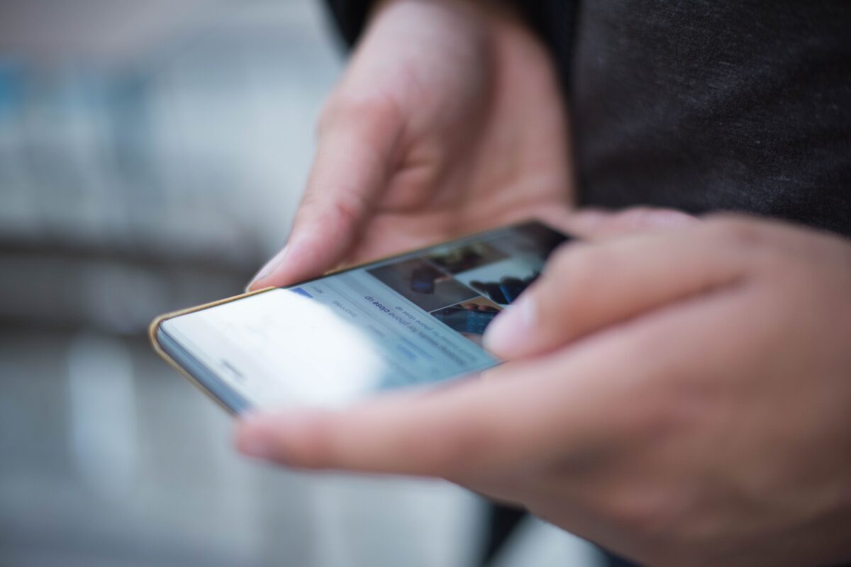 Close-up of hands using a smartphone with a touchscreen, emphasizing mobile technology.