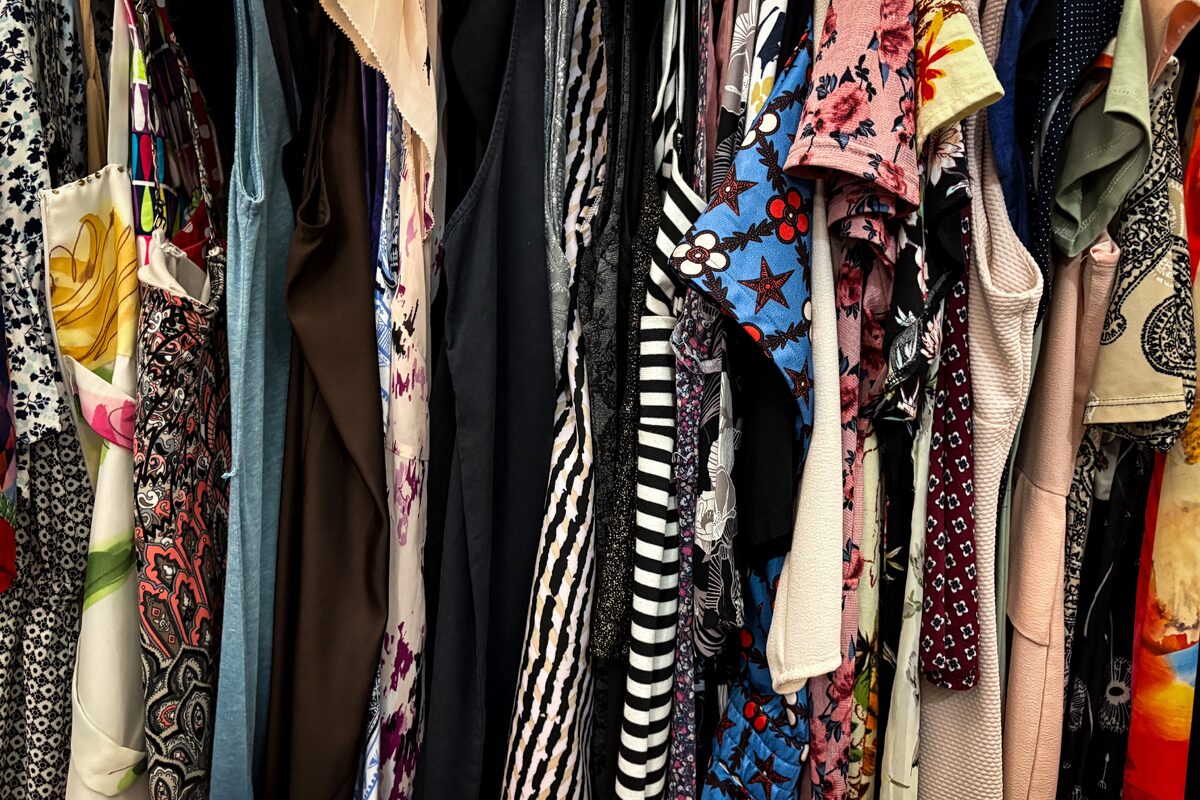 Vibrant collection of assorted vintage clothes hanging on a rack, showcasing patterns and styles.